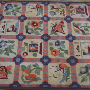 Cream rug with purple and coral grid framing squares filled with various floral and folk motifs.