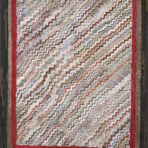 Heavily textured rug featuring a multicolored zigzag pattern bordered by wide stripes of red and dark brown.