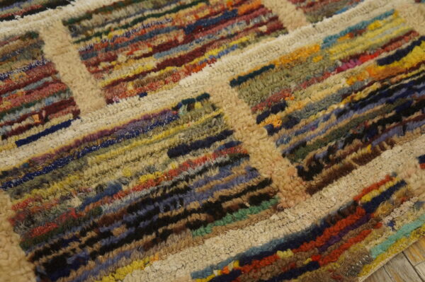 Shaggy rug texture showing thick cream lines separating dense blocks of multicolored fibers.