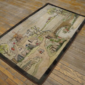 Textured loop pile rug with a village scene, bridge, and windmill rests on distressed wood flooring.