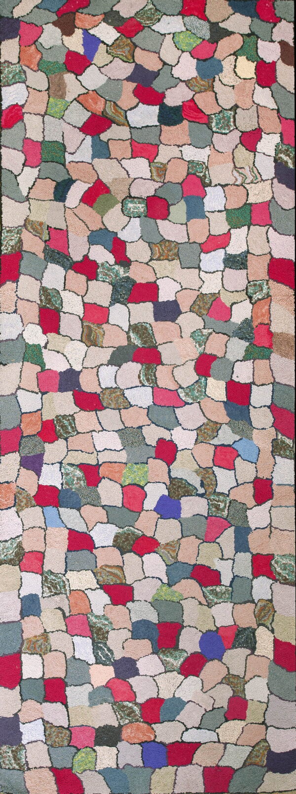 Hooked rug featuring a multicolored, irregular cobblestone pattern using red, blue, green, and neutral patches.