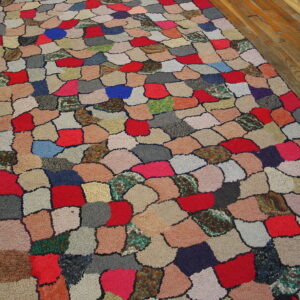 Colorful high-pile rug with an irregular, scaled patchwork pattern rests on a polished wood floor.