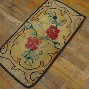 Low-pile rectangular rug featuring red roses and teal foliage on a yellow field over wood flooring.
