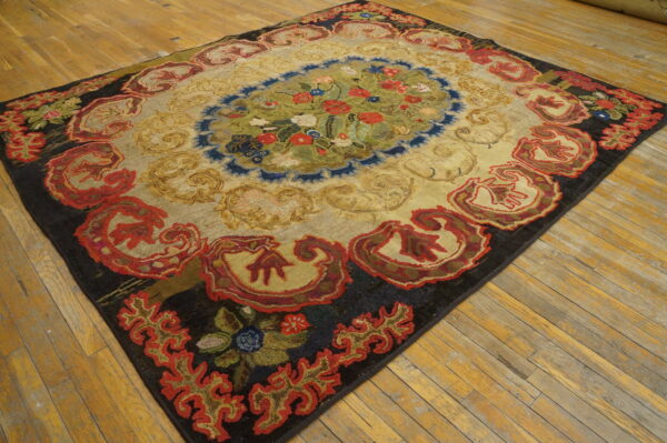 Textured rug with a floral medallion, deep red border, and gold field displayed on worn wooden plank flooring.
