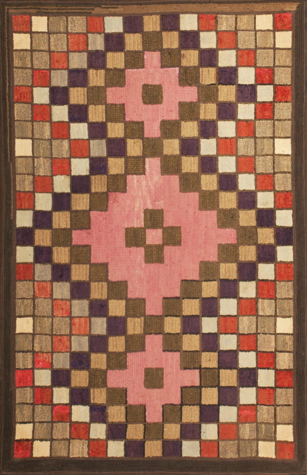 Multi-colored, square-patterned rug with dark borders and a prominent pink geometric motif at the center.