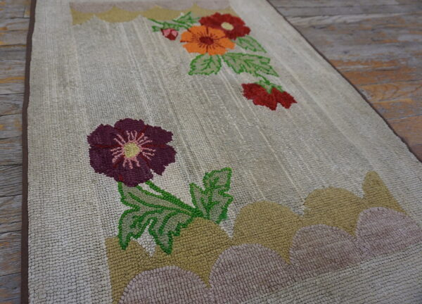 Hooked cream runner rug with purple, orange, and green floral accents over rustic wooden flooring.