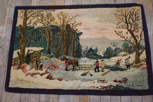 Hooked rug depicting a snowy winter landscape with trees, figures, and a pink sky on wood flooring.