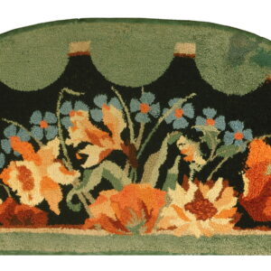 Semicircular rug with a black field featuring orange and blue flowers, framed by a scalloped sage green border.