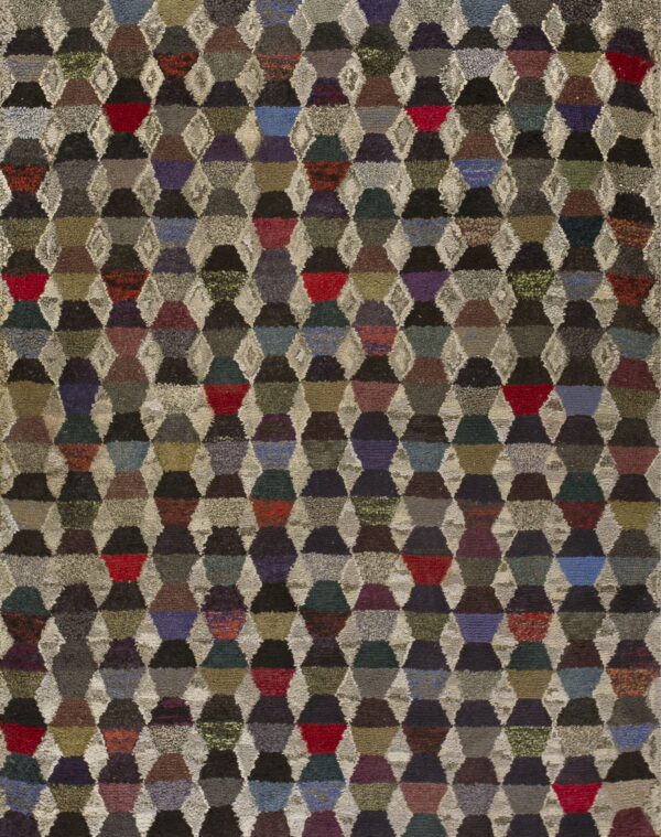 Textured rug with a multicolored, repeating pattern of dark geometric shapes separated by light, shaggy diamonds.