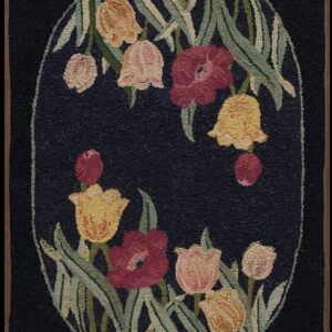 Black rug featuring a central oval medallion of stylized flowers in red, pink, yellow, and green.