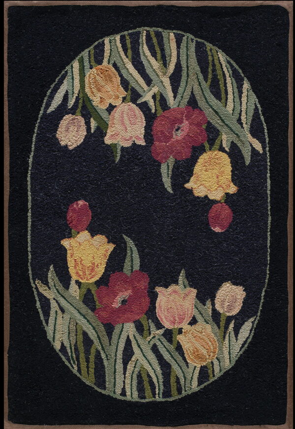 Black rug featuring a central oval medallion of stylized flowers in red, pink, yellow, and green.