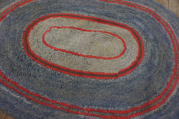 Concentric blue and light gray high-pile rings are separated by red and dark gray braided cords.