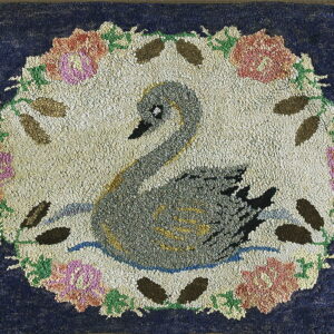 Textured dark blue rug featuring a gray swan in a floral medallion with pink and green accents.