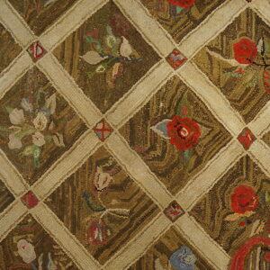 Coarse-textured rug featuring a brown diamond lattice pattern filled with red and multicolor floral motifs.