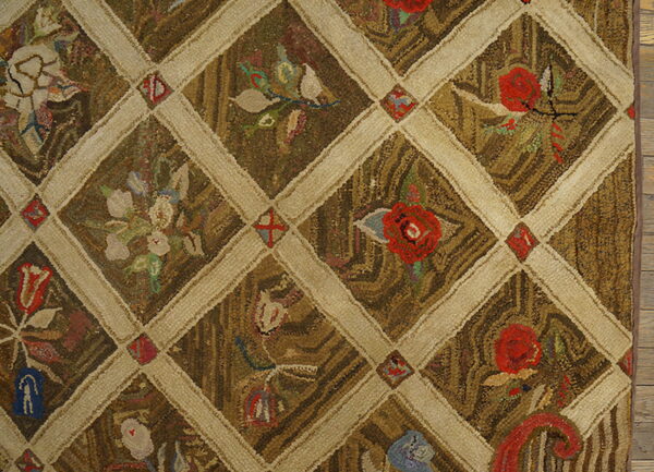 Coarse-textured rug featuring a brown diamond lattice pattern filled with red and multicolor floral motifs.