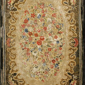 Gold and brown textured rug with a dense red and blue floral medallion and ornate scrollwork.