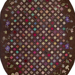 Dark brown oval rug featuring a high-pile, multicolored diamond patchwork grid bordered by floral designs.