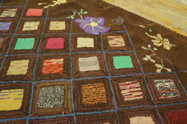 Shaggy brown rug featuring a blue grid pattern with multicolored square patches and stylized flowers.