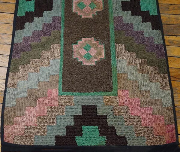 Textured geometric rug runner in teal, brown, dusty pink, and olive, featuring medallions on a rustic wood floor.
