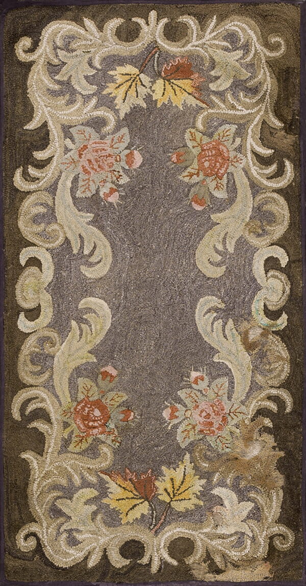 A dark brown hooked rug features a central grayish-brown field framed by ornate cream and rust floral scrollwork.