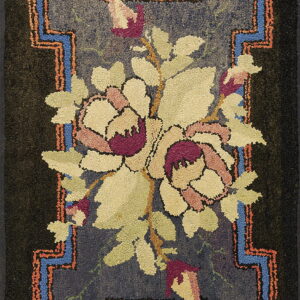 Hooked rug with a light floral bouquet on a dark blue ground and geometric blue and coral borders.