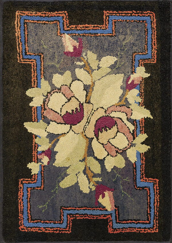 Hooked rug with a light floral bouquet on a dark blue ground and geometric blue and coral borders.