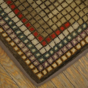 Geometric, textured rug with earthy and colorful square patterns shown on distressed wood planks.