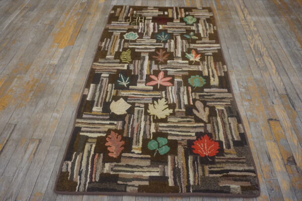 Brown log cabin runner rug with scattered colorful leaves rests on distressed gray wood flooring.