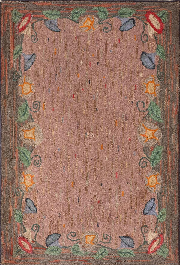 High-texture rug featuring a dusty rose field, vertical dashes, and a winding floral border of leaves and blossoms.