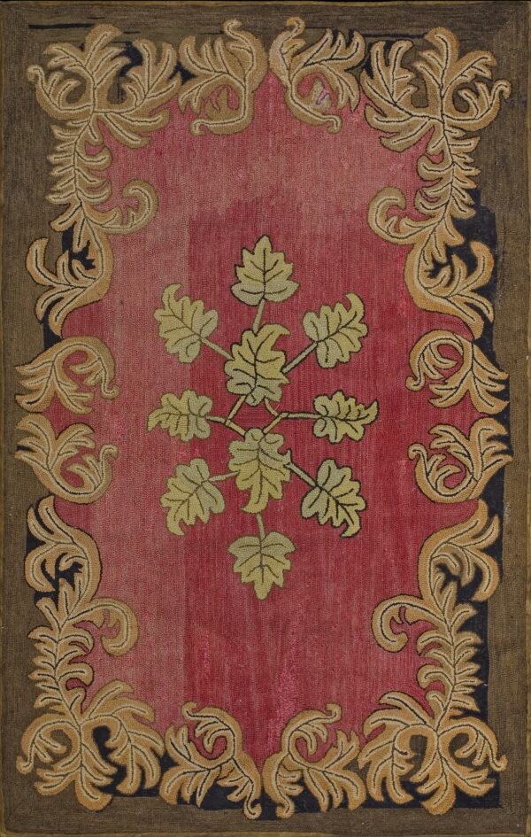 Hooked rug featuring a mottled pink field, a central yellow-green leaf cluster, and an elaborate gold acanthus border.