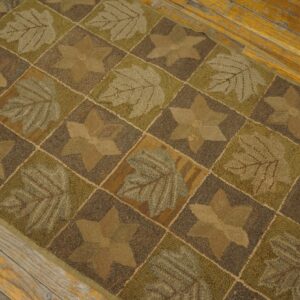 Textured brown and olive green runner with leaf and star blocks sits on aged wood flooring.