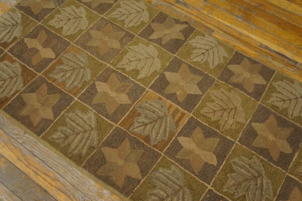 Textured brown and olive green runner with leaf and star blocks sits on aged wood flooring.