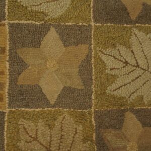 Low-pile hooked rug detail showing brown, olive green, and tan squares with leaf and star designs.