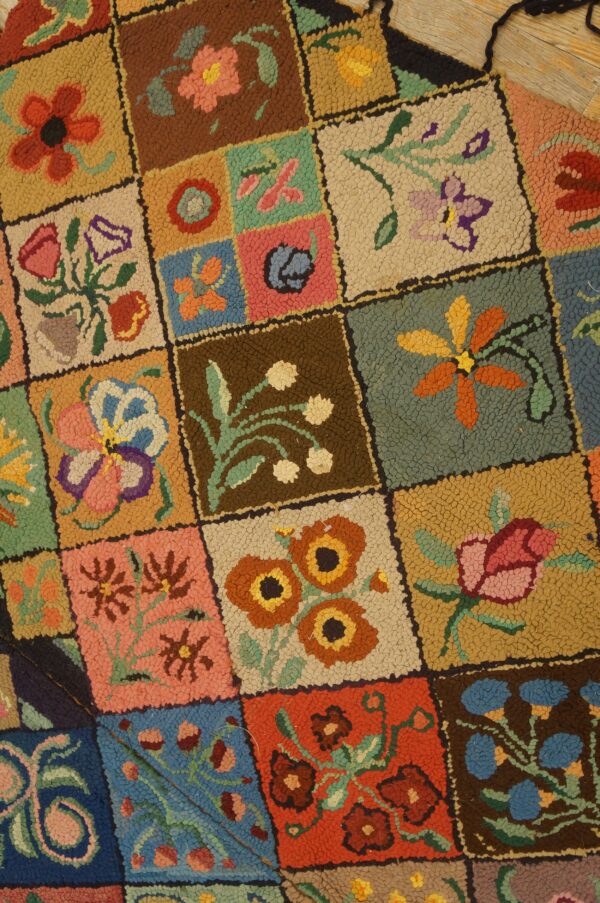 Textured, multi-colored hooked rug with a patchwork design featuring individual squares of diverse floral motifs.