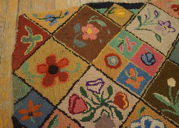 Textured floral hooked rug featuring colorful diamonds in pink, blue, rust, and gold on rustic wood planks.