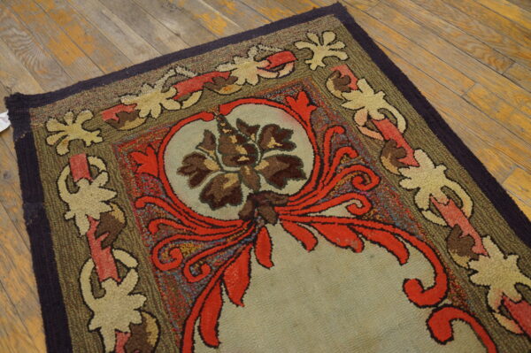 Textured, looped rug showing a central floral medallion and scrolling borders in red, brown, tan, and olive.