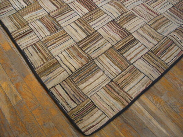 Multi-toned textured rug with a striped block pattern and dark border on honey-toned wood floors.
