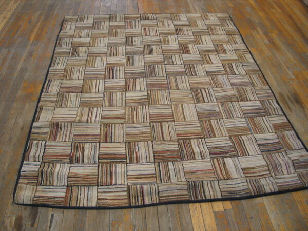 Patchwork rug featuring striped beige, tan, and brown squares displayed on distressed wood planks.