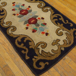High-pile rug featuring a cream central floral panel bordered by dark blue and tan Baroque scrolls on wood floors.