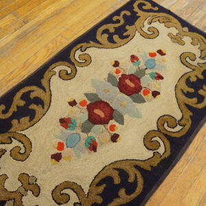 A detailed runner rug with navy border, gold scrolls, and colorful florals rests on hardwood.