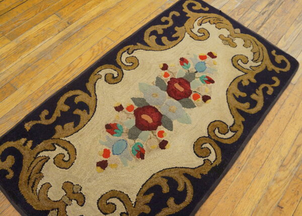 A detailed runner rug with navy border, gold scrolls, and colorful florals rests on hardwood.