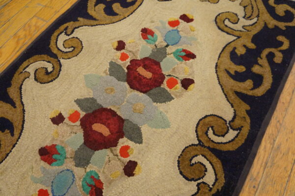 A textured rug displays red and blue floral medallions framed by gold scrollwork on a cream background.
