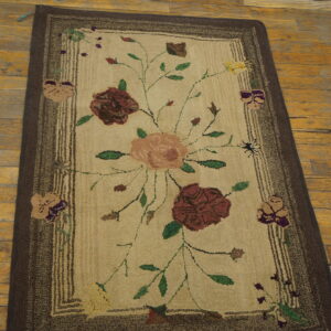 Textured floral runner rug with burgundy, peach, and green colors, bordered in dark brown on wood floor.