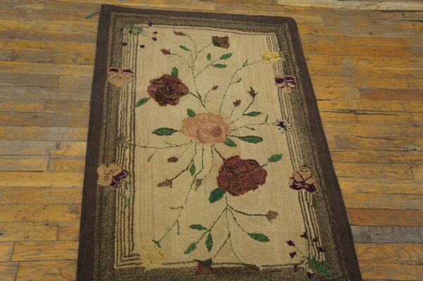 Textured floral runner rug with burgundy, peach, and green colors, bordered in dark brown on wood floor.