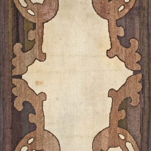 A brown and cream rug features large, stylized scrolled keyhole motifs framing a light central field.