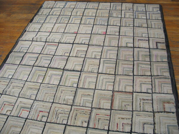 Light geometric rug with dark gray grid lines and textured squares on brown hardwood floor.