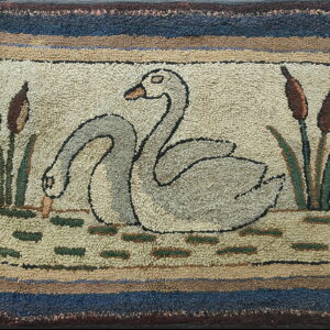 Highly textured beige rug with a pond scene pattern showing two gray swans and brown cattails.