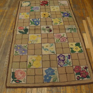 Textured multicolored floral checkerboard rug laid out on a distressed wooden floor.