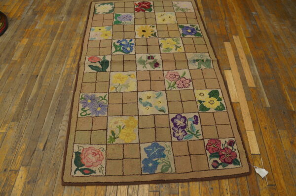 Textured multicolored floral checkerboard rug laid out on a distressed wooden floor.