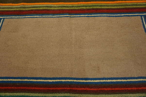 Tan textured rug with multicolored striped borders in brown, blue, red, green, and orange.